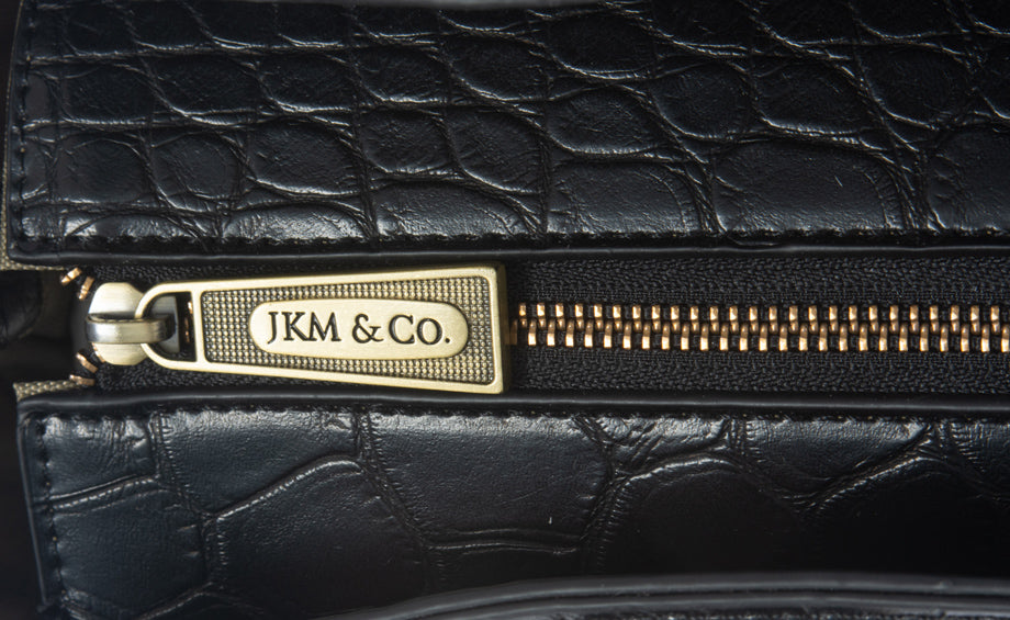A detailed view of the branded zipper that secures the main compartment where you can store your laptop, keys, wallet, phone, notebooks, files, folders, lunch bag, gym clothes, and more! 