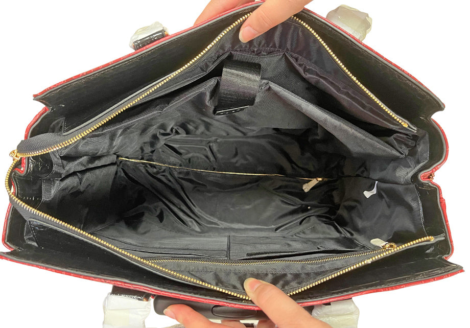 Interior of the stylish scarlet rolling laptop tote showing the attached padded laptop sleeve with velcro to secure it. It also shows the large zipper pocket to hold valuables and multiple smaller pockets and pen slots to keep you organized. This structured, wheeled work tote keeps school supplies, medical charts, or legal briefs in order making it ideal for law school, nursing shifts, or the classroom. A great organization-focused gift for women who are always fashion forward and on the move.