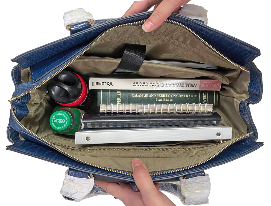 Interior view of The Riviera: packed with work and travel essentials- laptop, notebooks, textbooks, books, files, planners, folders, chargers, water bottle, and pens. The spacious interior and multiple pockets keep your belongings tidy and orderly. This wheeled business tote helps busy women stay organized from morning meetings to red-eye flights. Its vertical build and well-designed compartments keep everything in place, making it perfect for daily commuting, travel, or hybrid work schedules.