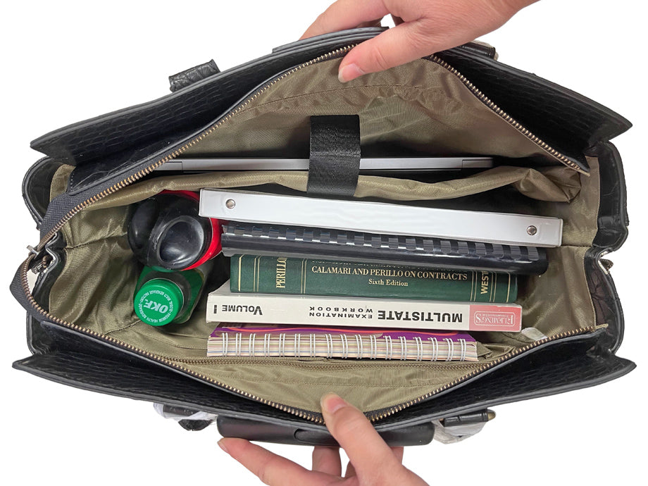 Interior view of the Firenze laptop bag filled with a laptop, notebooks, textbooks, pens, wallet, keys, phone, and other work and travel essentials. Features a padded laptop sleeve and multiple pockets for ultimate organization on the go.