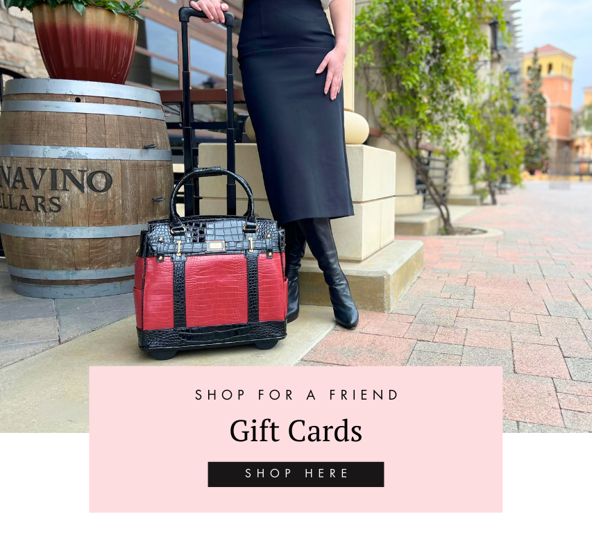 Long skirt with boots female business formal outfit. Woman at a winery in front of wine barrels with plants and ivy and elegant walkway. Woman stands with briefcase with wheels for lawyers teacher bags nurse bags doctor bags and gifts for realtors graduation and teacher appreciation week. This black and red alligator patterned vegan leather laptop bag for women stylish is the perfect gift for teachers or gift for grad students. Gift cards available on our website for gifts for friend or gifts for mom