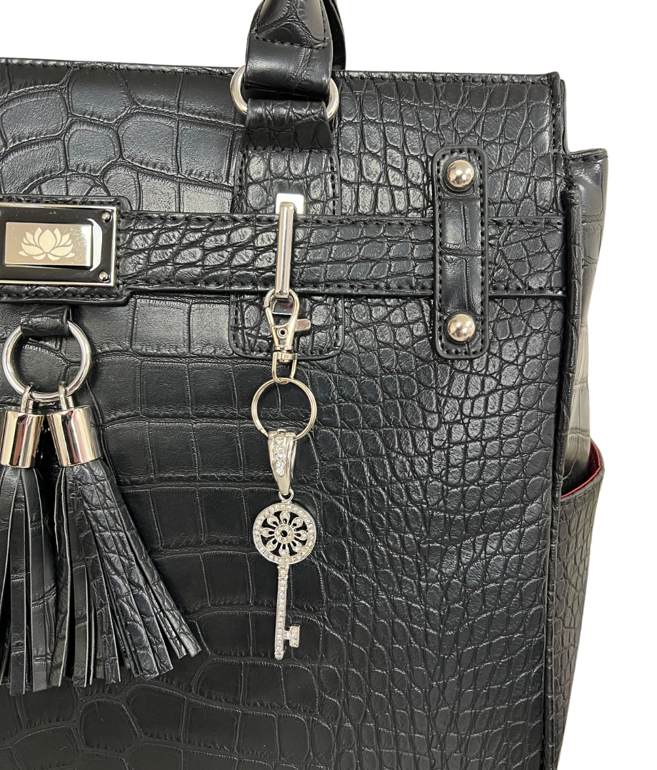 This bling bag charm is the perfect touch of sparkle to add to your bags, suitcases, messenger bags, tote bags, wallets, water bottles, and keychains. This silver charm on our black alligator Timeless bag helps you make your bag unique and elegant!
