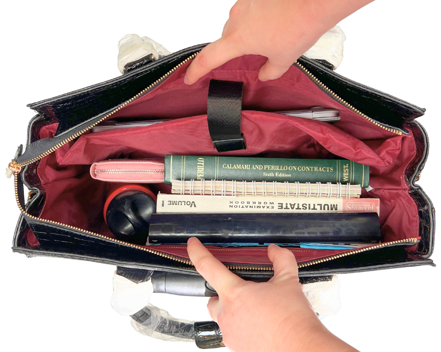 Work essentials and must haves such as a laptop, charger, cords, book, notebooks, planners, wallet, keys, phone, water bottle, and pens are organized in a laptop tote with wheels. This bag has multiple pockets including a zipper pockets, padded laptop sleeve, pen slots, multiple smaller pockets, two side pockets, and a back zipper pocket.