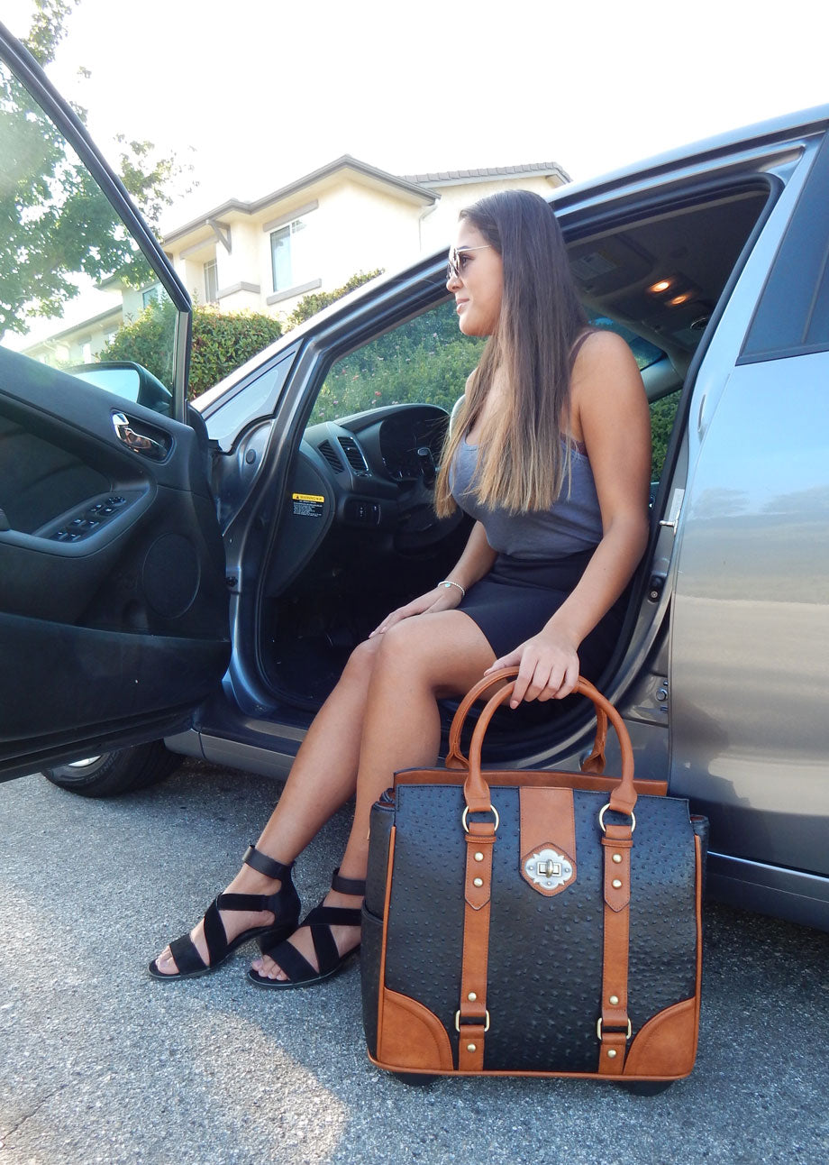 A woman is about to exit her luxury car in a stylish outfit with fancy heels. She has her briefcase womens bags and purses with her. This computer bag on wheels is perfect for toting her daily work essentials and travel essentials.